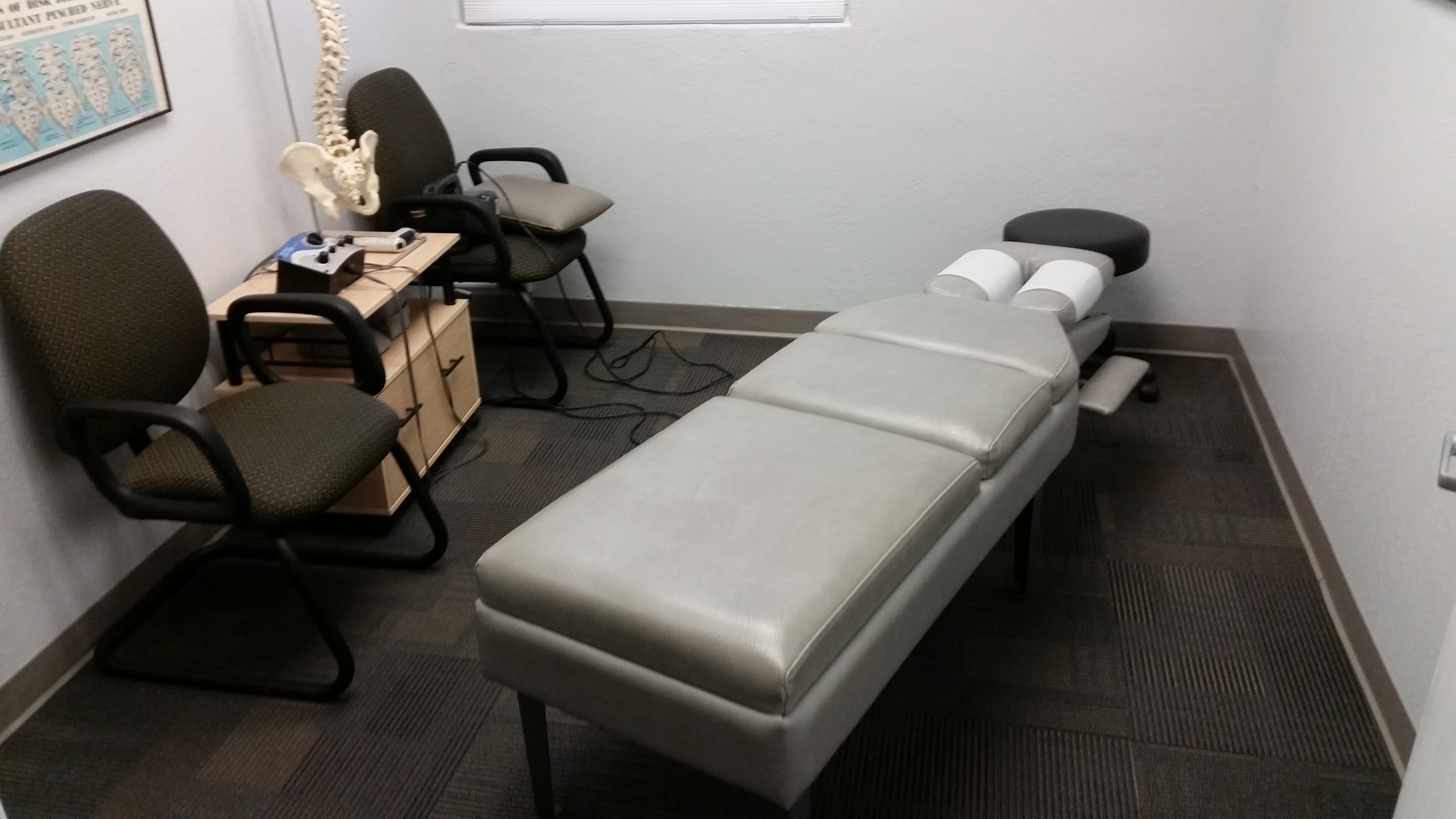 view of chiro therapy room with adjustment table and low-volt electrotherapy machine
