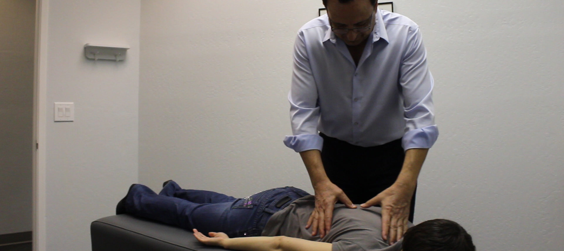 young man receiving chiropractic adjustment for back pain by Dr. Sam Nijmeh