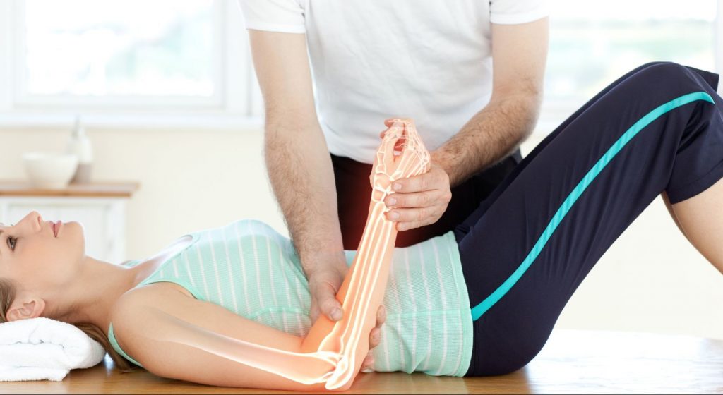 patient with hand wrist pain being adjusted on chiropractic table digital composite view